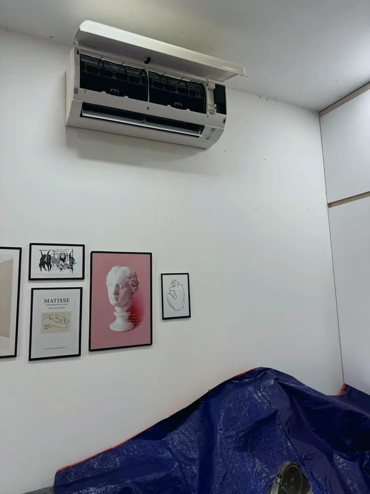 Trải bạt che chắn đồ đạc trước khi vệ sinh máy lạnh trong phòng khách